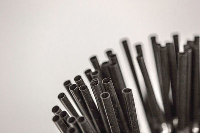 Close-up of black drinking straws against white background