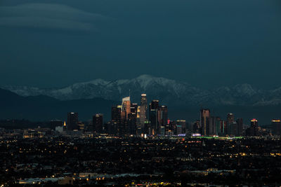 Illuminated cityscape against sky at night