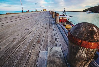 Boats moored at harbor against sky