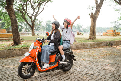 Man riding motor scooter on road