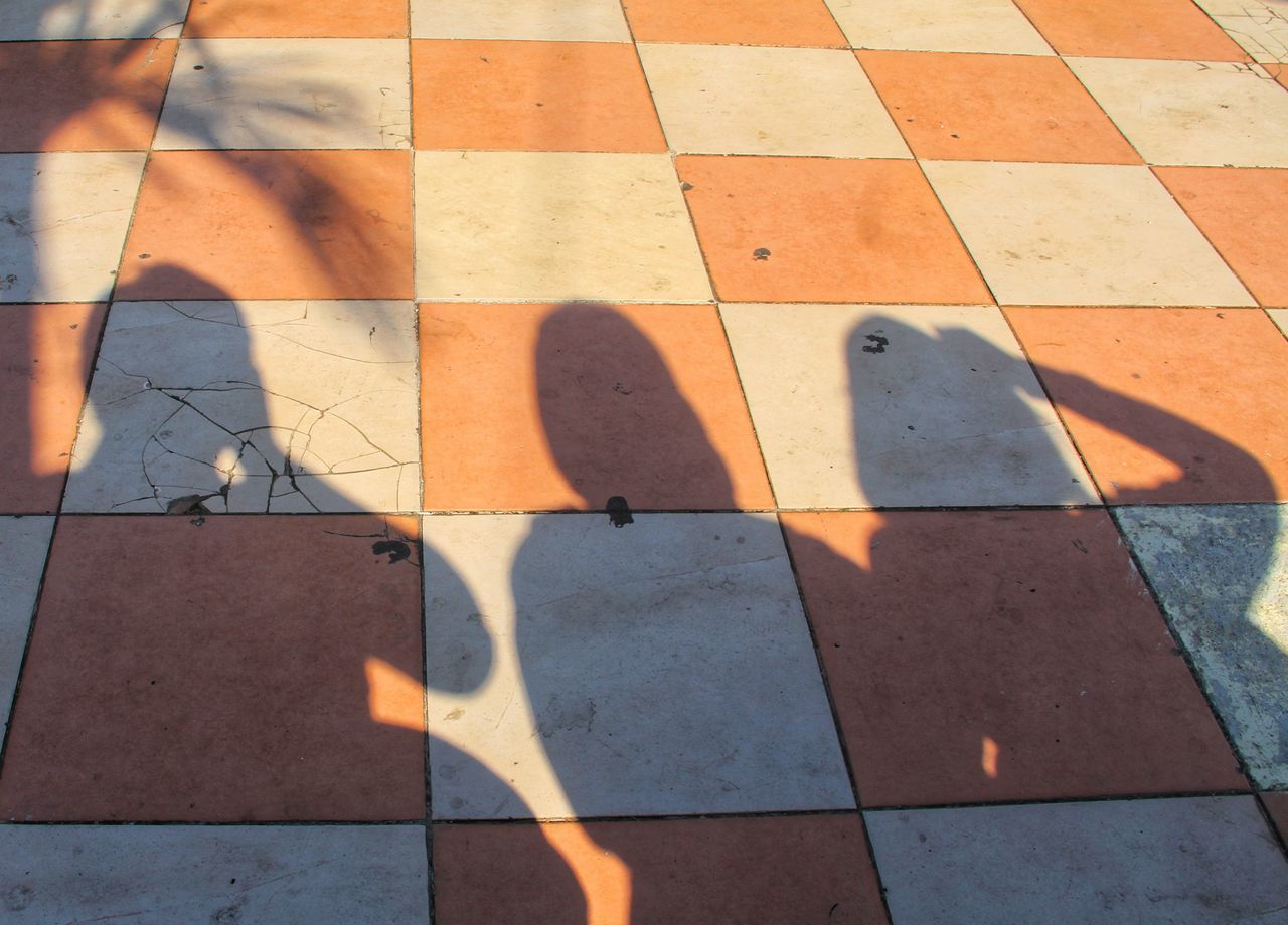 SHADOW OF PEOPLE ON TILED FLOOR