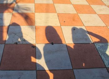 High angle view of shadow on tiled floor