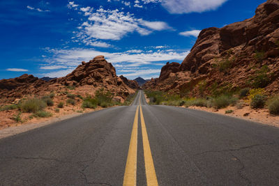 Empty road by mountain against sky