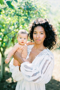 Mother with daughter standing outdoors