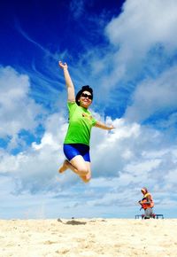 Low angle view of man playing on beach against sky