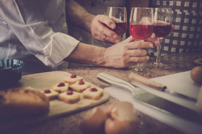 Midsection of men holding wineglasses