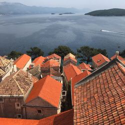 High angle view of townscape by sea against sky