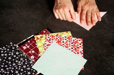 Cropped hands folding paper on table