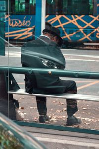 Man sitting on bench in city