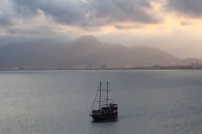 Ship in sea against mountains