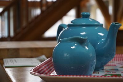 Close-up of blue teapot and container on table