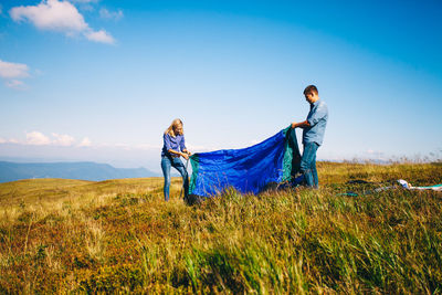 Man standing on field against blue sky