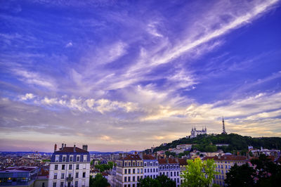 Buildings in city against sky during sunset