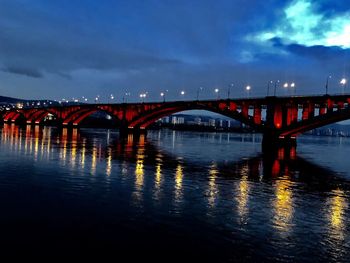 Bridge over river against sky at night