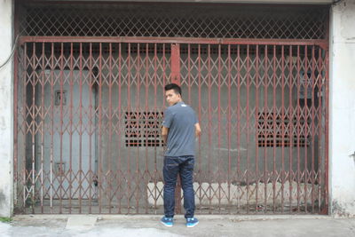 Full length portrait of man standing against building