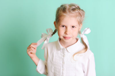 Portrait of smiling girl against blue background