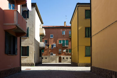 Street amidst buildings against clear sky