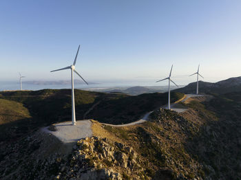 Low angle view of windmills against clear sky