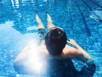 Rear view of children playing swimming in pool