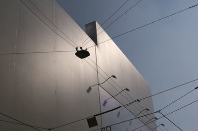 Low angle view of power lines against sky