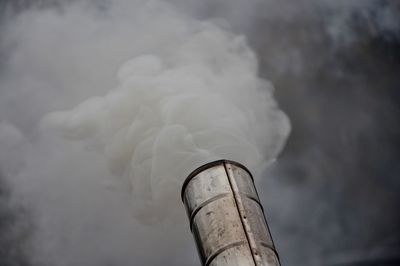 Smoke emitting from chimney against sky