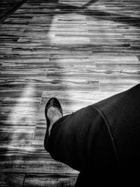 Low section of man standing on hardwood floor