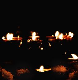 Close-up of lit candles burning at night