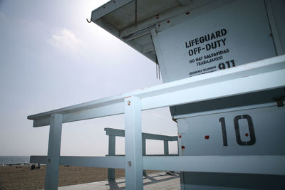 Information sign on sea against sky