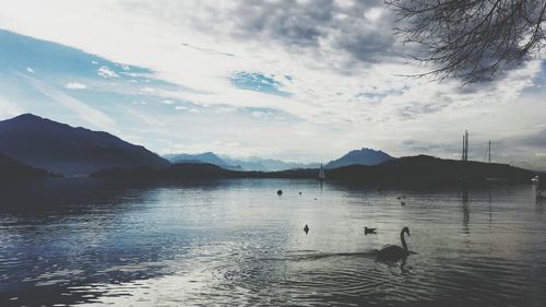 Scenic view of lake and mountains against cloudy sky