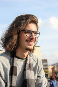 Portrait of smiling young woman against sky