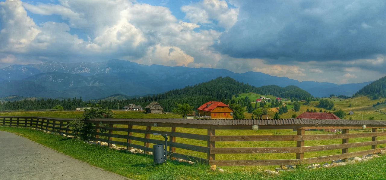 mountain, sky, landscape, tranquil scene, tranquility, cloud - sky, mountain range, scenics, rural scene, beauty in nature, agriculture, field, nature, cloud, farm, cloudy, fence, tree, green color, built structure