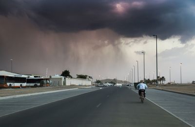 Rear view of man on street against sky