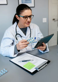 Mid section of man holding eyeglasses on table