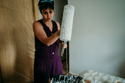 Portrait of woman standing against wall