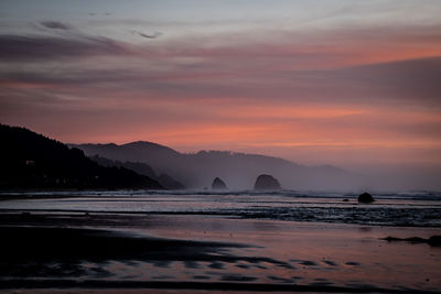 Scenic view of sea against orange sky