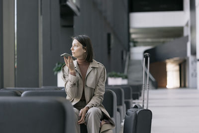 Woman talking on smart phone sitting in lobby