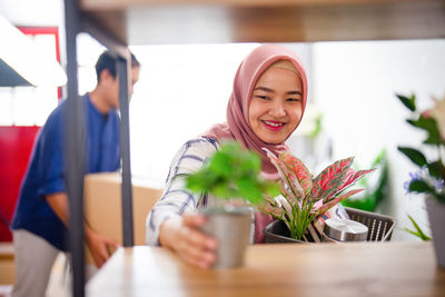 Portrait of smiling young woman sitting on table