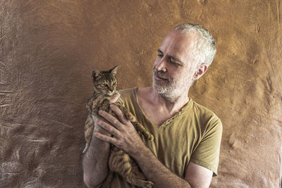 Portrait of man holding a kitten