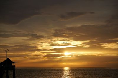 Scenic view of sea against dramatic sky during sunset