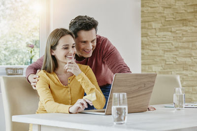 Happy couple at home shopping online