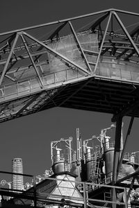 Low angle view of crane in city against sky