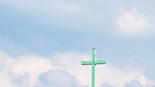 Low angle view of cross against sky