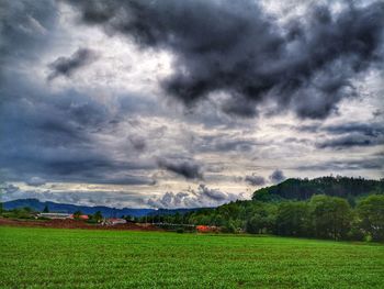 Scenic view of field against cloudy sky