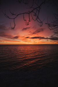 Scenic view of sea against dramatic sky during sunset