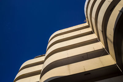 Low angle view of modern building against blue sky