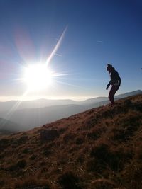 Silhouette of woman jumping on landscape