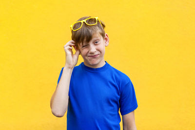 Portrait of smiling man standing against yellow wall