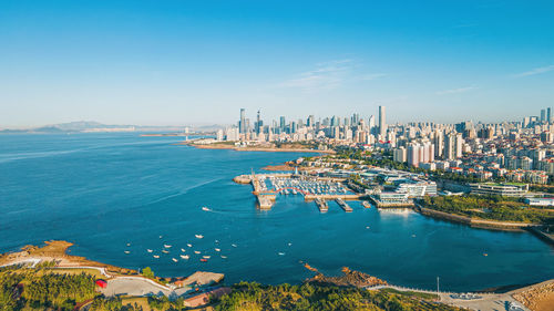 High angle view of townscape by sea against sky