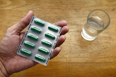 High angle view of hand holding drink on table