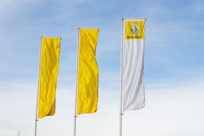 Low angle view of yellow flags against sky